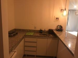 a kitchen with a sink and a counter top at Flat moderno com piscina e academia in Itaboraí