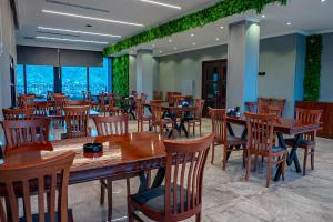 a restaurant with wooden tables and chairs and windows at Sofia Hotel in Duhok