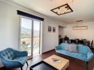 una sala de estar con muebles azules y una gran ventana. en Panorama Apartment by Atlantic Holiday, en Funchal