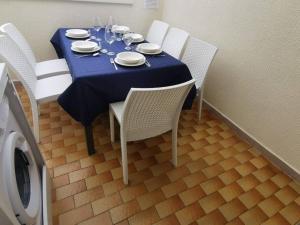 a table with a blue table cloth and white chairs at Paradiso Marino in Scalea