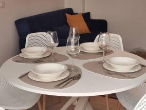 a white table with plates and wine glasses on it at Paradiso Marino in Scalea