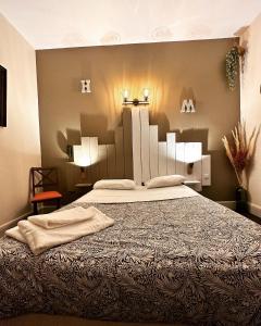 a bedroom with a large bed with two lights on it at Hotel Le Midi Clermont-Cournon in Cournon-dʼAuvergne