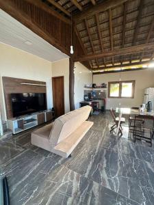 uma sala de estar com um sofá e uma televisão de ecrã plano em Barra Grande em Barra Grande