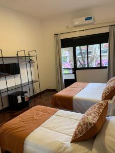 a hotel room with two beds and a window at Costa Rica Soho Rooms in Buenos Aires