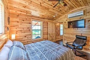 a bedroom with a bed and a tv and a chair at Mammoth Cave Cabin Rentals 1 in Cub Run
