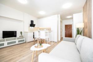 ein weißes Wohnzimmer mit einem Sofa und einer Küche in der Unterkunft ALURE RESIDENCES 2 & 24h self check-in with garage in Banská Bystrica