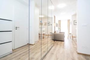 ein Wohnzimmer mit weißen Wänden und Glaswänden in der Unterkunft ALURE RESIDENCES 2 & 24h self check-in with garage in Banská Bystrica