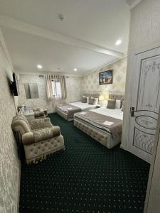um quarto de hotel com duas camas e um sofá em SEMURG HOTEL em Tashkent