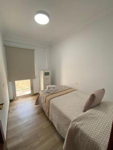 a bedroom with two beds and a window at Ático Playa Sardina in Gáldar