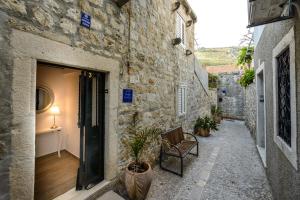 un callejón de piedra con una silla y una puerta en Alberto Apartment, en Dubrovnik