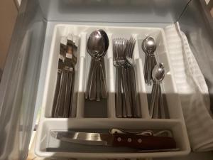 a tray with silver utensils in a drawer at The Anfield Apartment in Liverpool