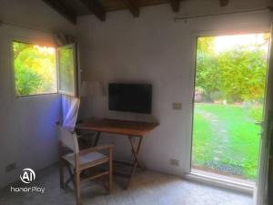 a room with a desk with a television and a window at Residenza ammiraglio Filippo in Varigotti