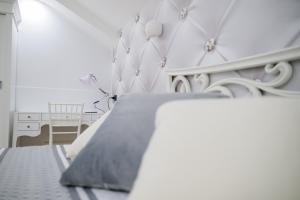 una camera bianca con un letto e una sedia di Venere apartement house a Montalto Uffugo