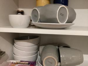 a shelf with plates and bowls and other dishes at The Anfield Apartment in Liverpool