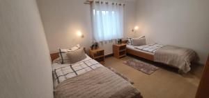 a bedroom with two beds and a window at Ferienhaus Frische Brise direkt am Nordsee Deich in Spieka-Neufeld +31 photos