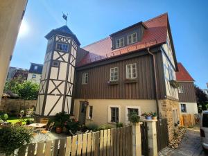 um edifício com uma torre de relógio em cima em außergewöhnliches, historisches, spätgotisches Wohnhaus von 1519, Gries 5 em Gera