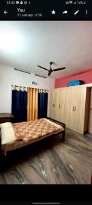 - une chambre avec un lit et un ventilateur de plafond dans l'établissement Maydale homes, à Kottayam