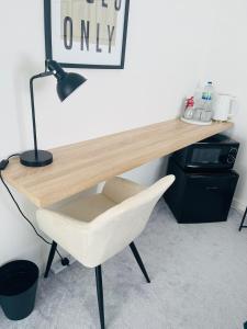 einen Schreibtisch mit einem weißen Stuhl und einer Lampe in der Unterkunft Simple Stay-Double Room Escape with Modern Luxury in Portchester