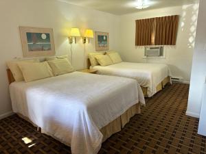 una habitación de hotel con 2 camas en una habitación en Ski's Western Motel en Great Falls