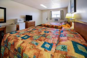 um quarto de hotel com duas camas e uma secretária em Canadas Best Value Inn Fort St John em Fort Saint John