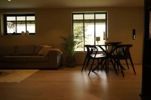 a living room with a table and chairs and a couch at Koselig leilighet i Langevåg in Holen