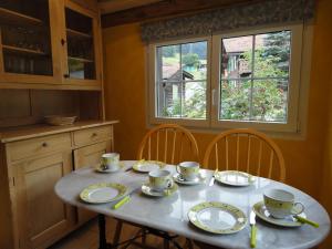uma mesa com pratos e chávenas na cozinha em Haus Corina em Klosters