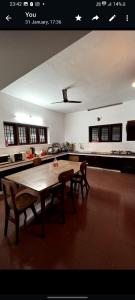 une cuisine avec une table en bois et deux chaises dans l'établissement Maydale homes, à Kottayam