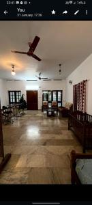 un grand salon avec un ventilateur de plafond dans l'établissement Maydale homes, à Kottayam