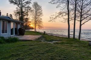 une maison sur la rive de l'océan au coucher du soleil dans l'établissement Waterfront Lake Michigan Hideaway Private Beach!, à Stephenson