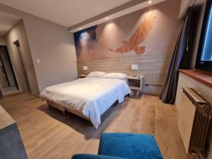 a bedroom with a bed and a painting on the wall at Hotel Alun Nehuen in San Carlos de Bariloche