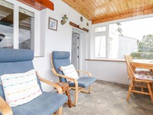a room with chairs and a table and windows at Squirrel Cottage in Keswick