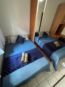dwa łóżka w pokoju z niebieską pościelą w obiekcie Excelente Quarto Próximo Ao Metrô w São Paulo