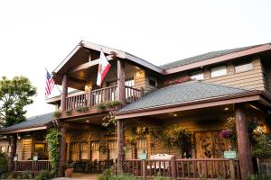 a large wooden house with an american flag on it at Cambria Pines Lodge in Cambria