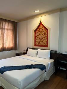 a bedroom with a large bed with a red headboard at Grand Phranakhon Hotel in Phra Nakhon Si Ayutthaya
