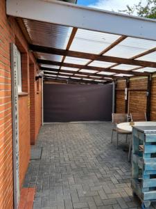 eine Terrasse mit Markise auf einem Backsteingebäude in der Unterkunft FEWO FloTi Ferienwohnung Augustfehn in Apen