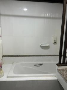 a white tub in a bathroom with a sink at Grand Phranakhon Hotel in Phra Nakhon Si Ayutthaya