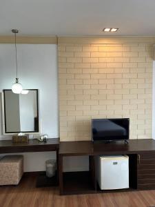 a living room with a television and a mirror at Grand Phranakhon Hotel in Phra Nakhon Si Ayutthaya +6 photos
