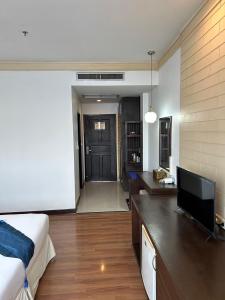 a bedroom with a bed and a desk with a television at Grand Phranakhon Hotel in Phra Nakhon Si Ayutthaya