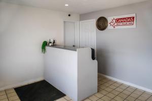 a kitchen with a white refrigerator in a room at Canadas Best Value Inn Fort St John in Fort Saint John