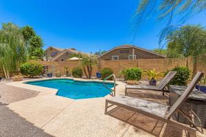 a backyard with a swimming pool and two chairs at Serenity Haven with Private Pool in Gilbert in Queen Creek