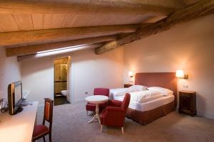 a bedroom with a bed and a table and chairs at Grand Hotel Della Posta in Sondrio