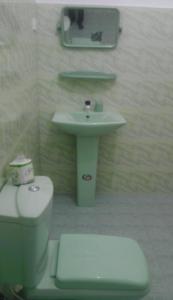 a bathroom with a toilet and a sink at Hotel Universal Beach in Hikkaduwa