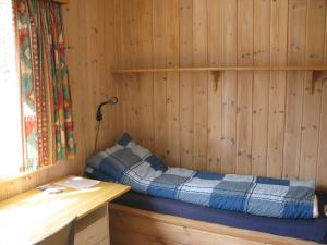 sypialnia z łóżkiem w drewnianej ścianie w obiekcie Hardanger Hostel B&B w mieście Lofthus