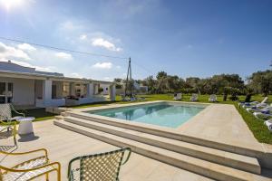 ein Swimmingpool mit Stühlen und ein Haus in der Unterkunft Villa Alice by Villa Plus in San Michele Salentino