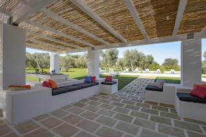 eine Terrasse mit weißen Möbeln und einer Holzdecke in der Unterkunft Villa Alice by Villa Plus in San Michele Salentino
