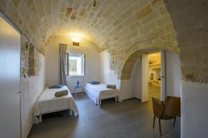 2 Betten in einem Zimmer mit einer Steinmauer in der Unterkunft Villa Alice by Villa Plus in San Michele Salentino + 26 Fotos