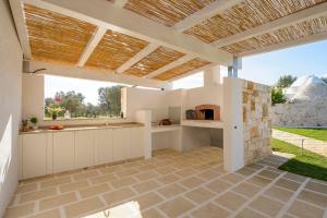 eine Außenküche mit Pizzaofen unter einer Pergola in der Unterkunft Villa Alice by Villa Plus in San Michele Salentino