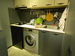 een keuken met een wasmachine en een wastafel bij Crimson Serenity Appartment in Ureki