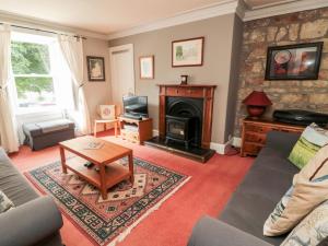 a living room with a couch and a fireplace at Simonside Apartment in Morpeth