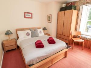 a bedroom with a bed with red towels on it at Simonside Apartment in Morpeth
